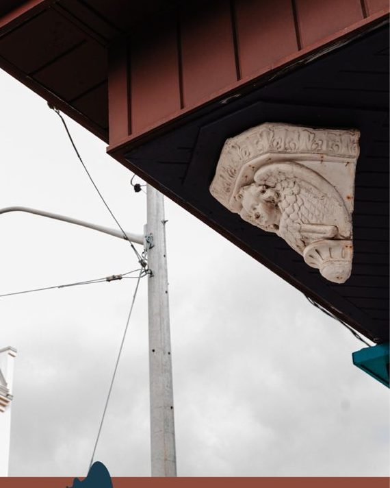 A carved winged figure under an old cornice on Mount Pleasant Road