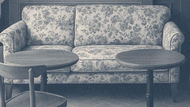 A floral sofa with two round café tables